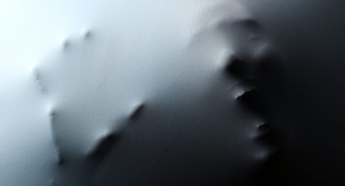 Screaming human face with hand pressing through fabric as horror background HORROR FILM